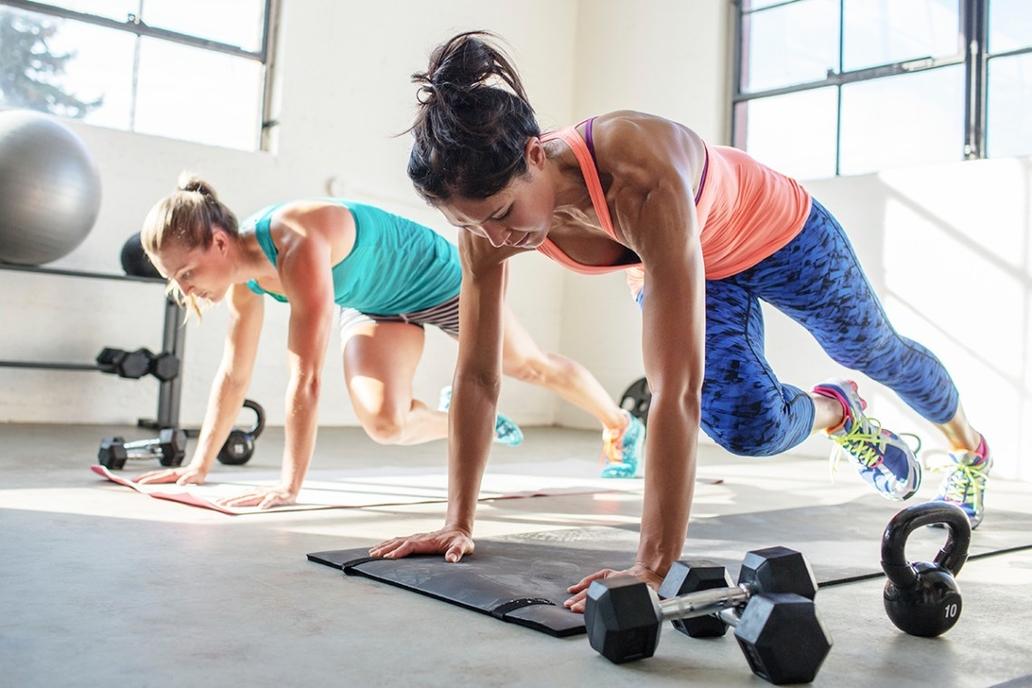 Women doing plank with alternating knee to elbow